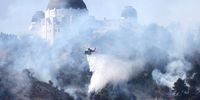 LOS ANGELES, CALIFORNIA - MAY 17: A firefighting helicopter performs a water drop over a brush fire near Griffith Observatory on May 17, 2022 in Los Angeles, California. The fire was burning near the observatory, the Greek Theatre and some residences in the vicinity. (Photo by Mario Tama/Getty Images)