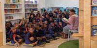 The Sunflower Learning Centre’s Sonica Petros reads to boys from Zonnebloem Boys School. (Photo: Andrea Stalbom)