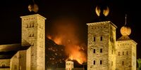 Smoke and flames rise from the burning forest behind the Stockalper palace and above the communes of Bitsch and Ried-Moerel, in Bitsch, Switzerland, 17 July 2023 (issued 18 July 2023). A forest fire broke out above Bitsch/Ried-Moerel in the Upper Valais on 17 July. Firefighters and two helicopters were deployed in the early evening to fight the flames. EPA-EFE/JEAN-CHRISTOPHE BOTT