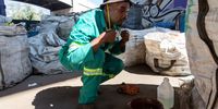Materials reclaimer Luyanda Hlatshwayo removes his mask after washing his hands at a makeshift sanitizing station set up as a measure to prevent the transmission of coronavirus, in  Johannesburg, South Africa, 19 March 2020. Recyclers, or reclaimers, are increasingly concerned of the impact of the coronavirus given that they work with materials from thousands of different people.  EPA-EFE/YESHIEL PANCHIA