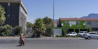 15 March 2022:A woman crosses the road in Hanover Park with Avril Andrews’ office in the background. Photographer: Barry Christianson FOR ONCE OFF USE ONLY