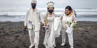 YOGYAKATA, INDONESIA - AUGUST 12: A groom, Gartijo, and a bride, Endang Tri, wearing protective masks walk as they attend a mass wedding to commemorate the 75th Indonesia's National Independence Day at Cemara Sewu beach amid the Coronavirus pandemic on August 12, 2020 in Yogyakarta, Indonesia. Indonesia became an independent nation on 17th August 1945, having previously been under Dutch rule. Indonesia is struggling to contain hundreds of new daily cases of coronavirus amid easing of rules to allow economic activity to resume, and has reported more than 100,000 coronavirus cases and with at least more 5,900 recorded fatalities. (Photo by Ulet Ifansasti/Getty Images)