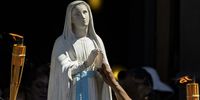 A Catholic pilgrim touches a statue of the Virgin Mary during a procession on Assumption Day in Paris, France, 15 August 2024. According to Roman Catholic belief, the Assumption is the day on which the Virgin Mary completed her earthly life and ascended to Heaven. It was established as a religious dogma by Pope Pius XII in 1950.  EPA-EFE/ANDRE PAIN