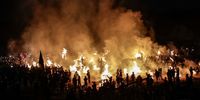 Soccer fans burn dry grass on the pitch inside the stadium during a rally marking the first anniversary of the soccer stampede at Kanjuruhan Stadium in Malang, East Java, Indonesia, 01 October 2023. Fans and family of the victims gathered at the stadium to mark the first anniversary of Kanjuruhan stadium stampede that killed at least 135 people following the soccer match between Arema FC and Persebaya Surabaya in East Java on 01 October 2022, after police fired tear gas to stop soccer fans from entering the pitch causing panic.  EPA-EFE/MAST IRHAM