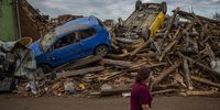 epa09300189 A woman walks past damaged cars after a tornado hit in Mikulcice, Czech Republic, 25 June 2021. A rare tornado on 24 June evening swept through the region of South Moravia, in south-eastern Czech Republic, leaving thousands of houses destroyed and damaged, authorities announced. At least three people died, according to a spokesperson of the regional ambulance service.  EPA-EFE/MARTIN DIVISEK