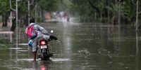 epa09228572 Locals wade through a flooded area as Cyclone Yaas makes landfall in Digha, near the Bay of Bengal, south of Kolkata, India, 26 May 2021. The Odisha and Bengal governments started the evacuation of at-risk areas, as Cyclone Yaas hits the eastern coast of India.  EPA-EFE/PIYAL ADHIKARY