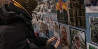 KYIV, UKRAINE - FEBRUARY 02: Yaroslava, the daughter of killed Ukrainian soldier Ihor Bezogluk, puts his photo on the part of the memorial wall for Ukrainian soldiers killed since the full-scale Russian invasion, in front of St. Michael's Golden-Domed Monastery, on February 2, 2023 in downtown Kyiv, Ukraine. February 24 will mark one year since Russia's large-scale invasion of Ukraine. In the time since, fighting has largely concentrated in the east and south of the country, but the capital remains the target of regular air strikes. (Photo by Roman Pilipey/Getty Images)