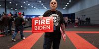 A volunteer passes out signs at a campaign rally hosted by President Donald Trump on April 02, 2024 in Green Bay, Wisconsin. At the rally, Trump spoke next to an empty lectern on the stage and challenged President Joe Biden to debate him. The Wisconsin primary is being held today. (Photo by Scott Olson/Getty Images)