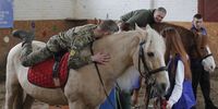 Ukrainian servicemenparticipate in hippotherapy at the Spirit rehabilitation center on the racecourse in Kyiv, Ukraine, 12 April 2023, amid Russia's invasion. More than 300 Ukrainian servicemen suffering from post-traumatic stress disorder have been treated at the center for mental healing since November 2022 where mental recovery is encouraged through communication with animals. Russian troops entered Ukraine on 24 February resulting in fighting and destruction in the country and triggering a series of severe economic sanctions on Russia by Western countries.  EPA-EFE/SERGEY DOLZHENKO