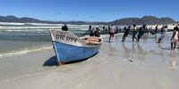Collecting supper from Strandfontein beach, Cape Town. Image: Lunga Newman