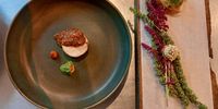 ‘Vanessa’s chicken’ four ways and on two plates. The liver mousse comes with amaranth chips. The amaranth flower ‘bed’ is from the garden. (Photo: Wanda Hennig)<br>