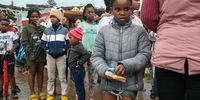 Children from the informal settlement between M19 and Quarry road line up for some food relief from Food Aid Foundation on April 12, 2022 in Durban, South Africa. (Photo by Gallo Images/Darren Stewart)