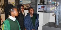 Three school pupils - Keisha Takwara (left), Fadzaishe Sambumba (middle) and Ashleigh Naube (right) - look at a small statute of late South African President Nelson Mandela at the ‘Nelson Mandela in Cape Town - Legacy Exhibition’ in Cape Town City Hall. The pupils were representing their school at a ‘Coding4Mandela’ event at City Hall. (Photo: Tamsin Metelerkamp)