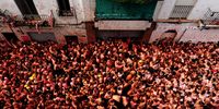BUNOL, SPAIN - AUGUST 26: Revellers pelt each other with tomatoes during the world's biggest tomato fight at La Tomatina festival on August 26, 2009 in Bunol, Spain. More than 45000 people from all over the world descended on the small Valencian town to participate in this year's La Tomatina festival, with the local town hall estimating that over 100 tons of rotten and over-ripe tomatoes were thrown.  (Photo by Jasper Juinen/Getty Images)
