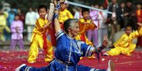 A senior citizen and children perform martial arts during an activity to display Chinese health Qigong on November 3, 2006 in Nanjing of Jiangsu Province, China. Qigong is a combination of two ideas: "Qi" meaning air, breath of life or vital energy of the body, and "gong" meaning the skill of working with, or cultivating self-discipline and self-healing. The art of Qigong consists primarily of meditation, relaxation, physical movement, mind-body integration, and breathing exercises. (Photo by China Photos/Getty Images)