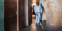 Jetro Gonese, 60, a blind person from Zimbabwe, walks in the corridor of the building in which he lives as he uses his white cane, in the Johannesburg CBD, on June 22, 2020. - Despite losing his sight to measles at the age of two, he completed his education and trained as a teacher for visually impaired children.<br>None of those qualifications were recognized in South Africa when he migrated here in 2008.<br>During times of the COVID-19 coronavirus where people keep their distance and avoid contact with surfaces, the blind have found themselves cut off from a key navigator. (Photo by Luca Sola / AFP)