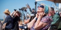 A person uses solar viewing glasses to look up at the sky ahead of a total solar eclipse at a viewing site 24km from Exmouth, Western Australia, Australia, 20 April 2023. The total solar eclipse will occur on a remote peninsula on the Western Australian coast.  EPA-EFE/AARON BUNCH  AUSTRALIA AND NEW ZEALAND OUT