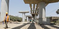 A Chinese construction worker (L) walks under an overpass bridge, at a section of the ongoing construction to expand the Outer ring road in Nairobi, Kenya, 02 August 2016. EPA/DANIEL IRUNGU