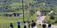 A group of Bhuje Junior Secondary School learners return from school. Ahead of them are some of the torched homesteads. School uniforms were burnt in houses set alight by a mob of about 200 men. (Photo: Hoseya Jubase).