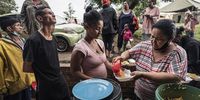 People stand in line waiting to receive food. Residents and neighbouring communities rallied to feed everyone at Dulcie Flats.<br>Photo / Shiraaz Mohamed