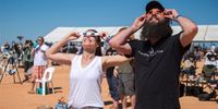 People use solar viewing glasses to watch a total solar eclipse at a viewing site near Exmouth, Western Australia, Australia, 20 April 2023.  EPA-EFE/AARON BUNCH  AUSTRALIA AND NEW ZEALAND OUT