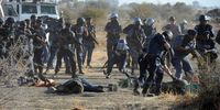 Police disarm Marikana mine workers after the shooting at the koppie. (Photo: Felix Dlangamandla)