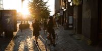 A cyclist rides down a street as the sun sets in Helsinki, Finland, on Monday, July 16, 2018. Photographer: Chris Ratcliffe/Bloomberg via Getty Images