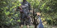 An endangered crowned crane and a member of the Guinean National Brigade for the Fight against Crime in Species of Wild Fauna and Flora at a raid on a private zoo in Guinea. (Photo: Nathalie Bertrams) 