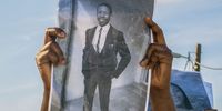 A marcher holds a photo of one of the deceased during the march to Enyobeni tavern in Scenery Park, East London. (Photo: Hoseya Jubase)