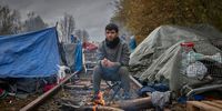 DUNKIRK, FRANCE - NOVEMBER 25: Alan Molani, 18, from Kurdish Iran, sits by a fire next to old railway tracks in the new Jungle in Dunkirk on November 25, 2021 in Dunkirk, France. At least 27 people including five women and a young girl died yesterday trying to cross the Channel to the UK in an inflatable dinghy in an incident which the International Organisation for Migration described as the biggest single loss of life in the Channel since it began collecting data in 2014. There are currently 1800 migrants and refugees currently living in Northern France. (Photo by Kiran Ridley/Getty Images)