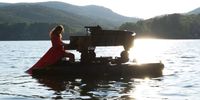 epa07752551 A pianist performs on a platform floating on Carucedo Lake as part of a concert of the French spectacle 'Le Piano du Lac' (lit.: The piano pf the lake) in Leon, northern Spain, 01 August 2019.  EPA-EFE/Ana F. Barredo