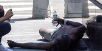 A person lays on the street near Times Square during a heatwave in New York, U.S., on Wednesday, June 30, 2021. Temperatures in New York and the Northeast will soar again Wednesday, while the heat wave in the western U.S. and Canada is easing after causing blackouts and several deaths. Photographer: Jeenah Moon/Bloomberg via Getty Images