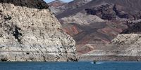 LAKE MEAD NATIONAL RECREATION AREA, NEVADA - JULY 28: A boat cruises by mineral-stained rocks in The Narrows upstream of the Hoover Dam on July 28, 2022 in the Lake Mead National Recreation Area, Nevada. Last week, Lake Mead dropped to just 27 percent of its capacity, with the water level at its lowest since being filled in 1937 after the construction of the Hoover Dam as a result of a climate change-fueled megadrought coupled with increased water demands in the Southwestern United States. The drought has left a white "bathtub ring" of mineral deposits left by higher water levels on the rocks around the lake. (Photo by Ethan Miller/Getty Images)