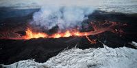 An aerial view taken with a drone shows lava and smoke spewing from a volcanic fissure during an eruption, near the town of Grindavik, in the Reykjanes peninsula, southwestern Iceland, 19 December 2023. The Icelandic Meteorological Office (IMO) announced the start of a volcanic fissure eruption near the Sundhnuka crater, north-east of Grindavik, on the night of 18 December, following weeks of intense earthquake activity in the area. The power and seismic activity of the eruption have decreased over time, IMO reported on 19 December, adding that since the eruption began, about 320 earthquakes have been recorded.  EPA-EFE/ANTON BRINK
