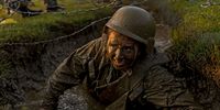 A Naval Academy Plebe crawls through a mud-filled trench while taking part in the "Wet and Sandy" portion of the annual Sea Trials at the U.S. Naval Academy on May 16, 2023 in Annapolis, Maryland. For the annual Sea Trials, the Naval Academy freshman class took part in a 14-hour series of rigorous exercises starting in the early hours of the morning as part of the culmination of their "Plebe" year at the academy. (Photo by Anna Moneymaker/Getty Images)