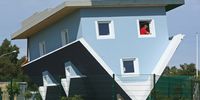 TRASSENHEIDE, GERMANY - SEPTEMBER 03:  A worker cleans a window of "The World Stands on its Head" ("Die Welt Steht Kopf") House on the Baltic Sea Island of Usedom on September 3, 2008 in Trassenheide, Germany. The upside down house, complete with interior furnishings, is the brainchild of Klaudiusz Golos and Sebastian Mikiciuk, and will become a local tourist attraction that will open its doors to the public tomorrow.  (Photo by Sean Gallup/Getty Images)