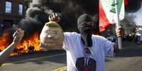An activist holds aloft a Mexican flag and an effigy of US President Donald J. Trump’s head as cars burn during protests sparked by immigration raids in Los Angeles, California, USA, 08 June 2025. US President Donald Trump has deployed 2,000 National Guard troops, despite not receiving a request from the state of California for any additional assistance, following large protests against ongoing immigration enforcement raids in the Los Angeles area over the last couple of days.  EPA-EFE/CAROLINE BREHMAN
