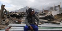 Buhle Ranega, 25, has to protect the land and materials needed to rebuild the home he shares with his brother and mother in Section E of Masiphumelele, which burnt down on 28 July 2019. (Photo: Tessa Knight)