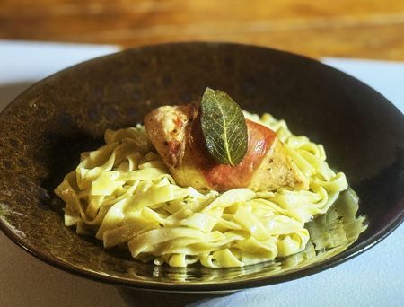 Prosciutto-wrapped chicken breasts with cheese and sage, served with tagliatelle