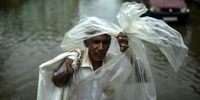 epa09589354 An Indian man has himself wrapped in a makeshift plastic cover as he crosses a waterlogged street following heavy rains, in Chennai, India, 18 November 2021. The India Meteorological Department (IMD) has issued a red alert for heavy rainfall expected in Chennai and its neighboring districts. Authorities declared holidays for schools and colleges in several districts in view of a weather depression over the Bay of Bengal.  EPA-EFE/IDREES MOHAMMED
