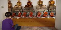 epa09830619 Thai Buddhist monks and a devotee pray to mark Buddhist Sabbath day at Wat Pho, the Temple of the Reclining Buddha, in Bangkok, Thailand, 17 March 2022. Thailand has logged more than 25,000 daily COVID-19 cases. However, the Public Health Ministry announced a transition plan to declare COVID-19 as an endemic disease by 01 July 2022.  EPA-EFE/RUNGROJ YONGRIT