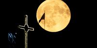 A full moon, also called Buck Moon, rises behind a 63.5 meters high cross and a North Macedonian flag on a hill near Dracevo, Skopje, Republic of North Macedonia, 21 July 2024.  EPA-EFE/GEORGI LICOVSKI