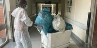 A volunteer from the Red Cross Society takes the trash out while cleaners strike at Pelonomi Hospital, Bloemfontein. (Photo: Refilwe Mochoari / Spotlight)