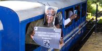 Commuters wore Fikile Mbalula’s photo on their faces. (Photo: Ashraf Hendricks)