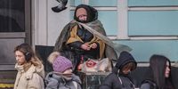 People walk past a woman sitting on the steps of the Belorussky railway station in Moscow, Russia, 10 February 2025.  EPA-EFE/YURI KOCHETKOV