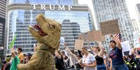 A person dressed in a dinosaur costume joins walks during a 'No Kings' protest in  downtown Chicago. (Photo: Cristobal Herrera-Ulashkevich / EPA)