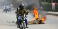 People ride a motorcycle past a burning pile of wood at a location where people vandalized stores during the first day of the taxi strike in Luanda, Angola, 28 July 2025. Angolan taxi drivers’ associations have called for a strike until 30 July in the main Angolan provinces as a form of protest against the increase in diesel prices at the beginning of this month, which led to an increase in public transport fares.  EPA/AMPE ROGERIO