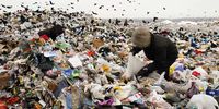 Homeless people scavenge for food on a rubbish tip near Moscow, Russia, 10 January 2003. (Photo: Oleg Nikishin / Getty Images)