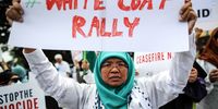A woman holds a placard during a White Coat Rally outside Egypt's embassy in Malaysia, to show solidarity with Gaza's doctors after Israel launched a military 'operation' inside Al-Shifa Hospital on 15 November; in Kuala Lumpur, Malaysia, 16 November 2023. On 15 November the largest hospital in Gaza - Al Shifa hospital - was raided by the Israeli Army. Under the Geneva Convention, hospitals must be protected, according to a press statement by Doctors And Healthworkers Against Genocide.  (Photo: EPA-EFE / FAZRY ISMAIL)