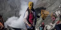PROBOLINGGO, EAST JAVA, INDONESIA - AUGUST 12:  A villager holds a net as they wait to catch offerings thrown by Hindu worshippers during the Yadnya Kasada Festival at crater of Mount Bromo on August 12, 2014 in Probolinggo, East Java, Indonesia. The festival is the main festival of the Tenggerese people and lasts about a month. On the fourteenth day, the Tenggerese make the journey to Mount Bromo to make offerings of rice, fruits, vegetables, flowers and livestock to the mountain gods by throwing them into the volcano's caldera. The origin of the festival lies in the 15th century when a princess named Roro Anteng started the principality of Tengger with her husband Joko Seger, and the childless couple asked the mountain Gods for help in bearing children. The legend says the Gods granted them 24 children but on the provision that the 25th must be tossed into the volcano in sacrifice. The 25th child, Kesuma, was finally sacrificed in this way after initial refusal, and the tradition of throwing sacrifices into the caldera to appease the mountain Gods continues today.  (Photo by Ulet Ifansasti/Getty Images)